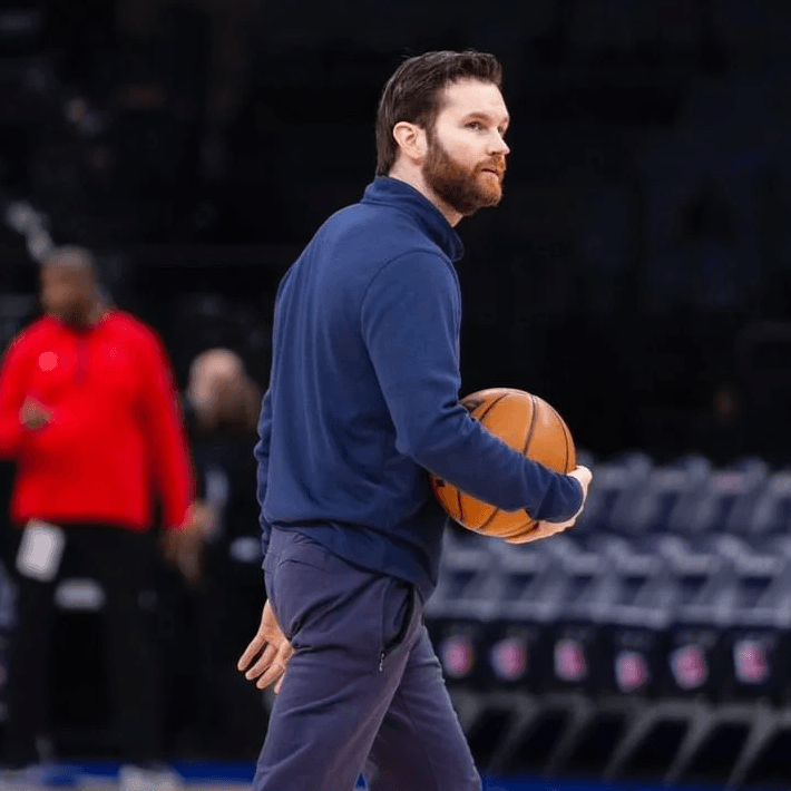 Man in "Integrity Hoops" shirt coaching basketball