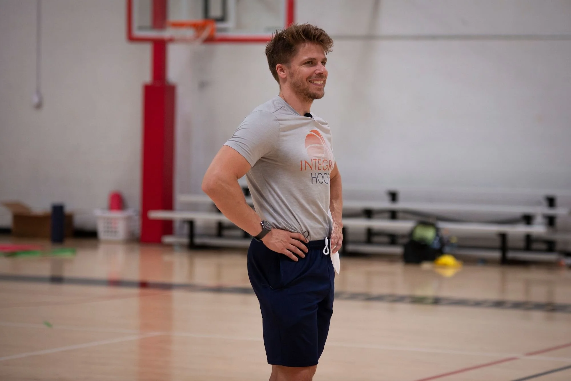 Man in "Integrity Hoops" shirt coaching basketball